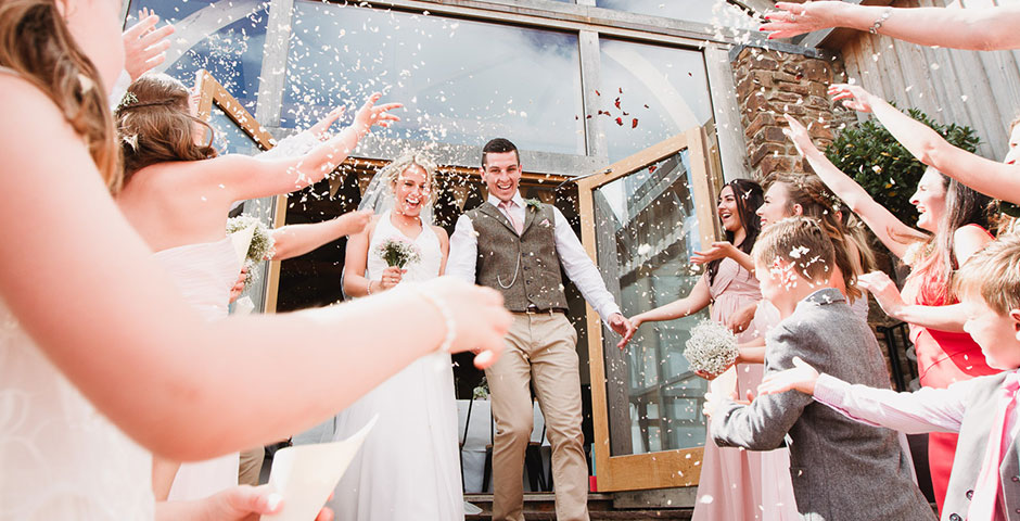 Confetti thrown at couple exiting the Cider Barn