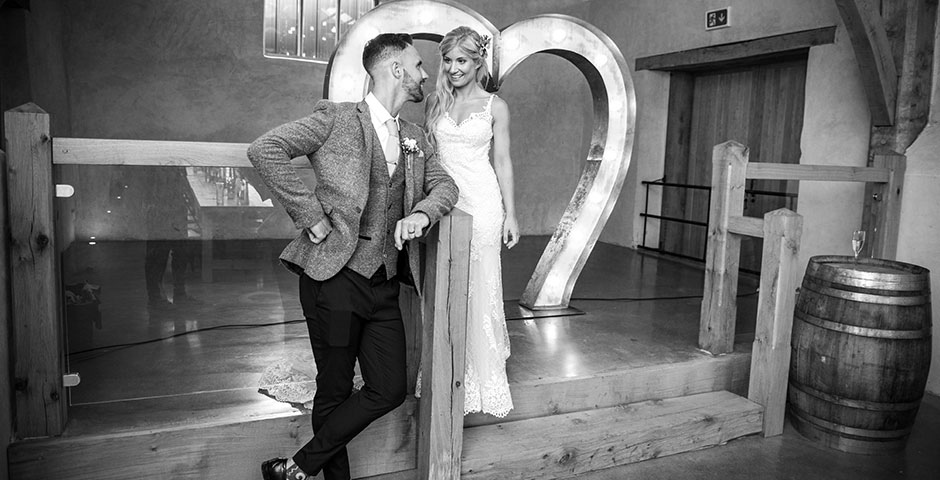 Couple pose by stage area of the Cider Barn