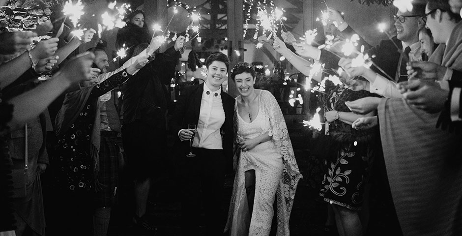 Archways of sparklers indoors for the same sex wedding